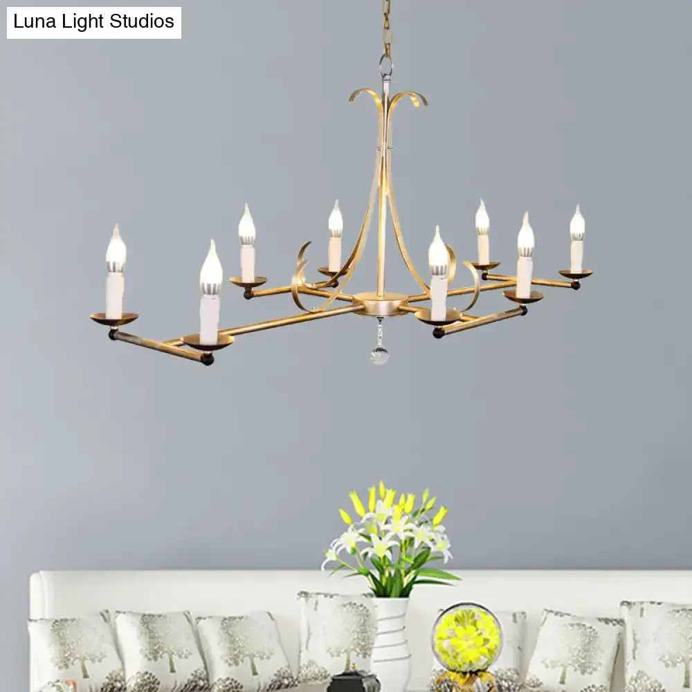Gold-toned metal island chandelier light with eight traditional candle bulbs and central crystal droplet by DecorBites