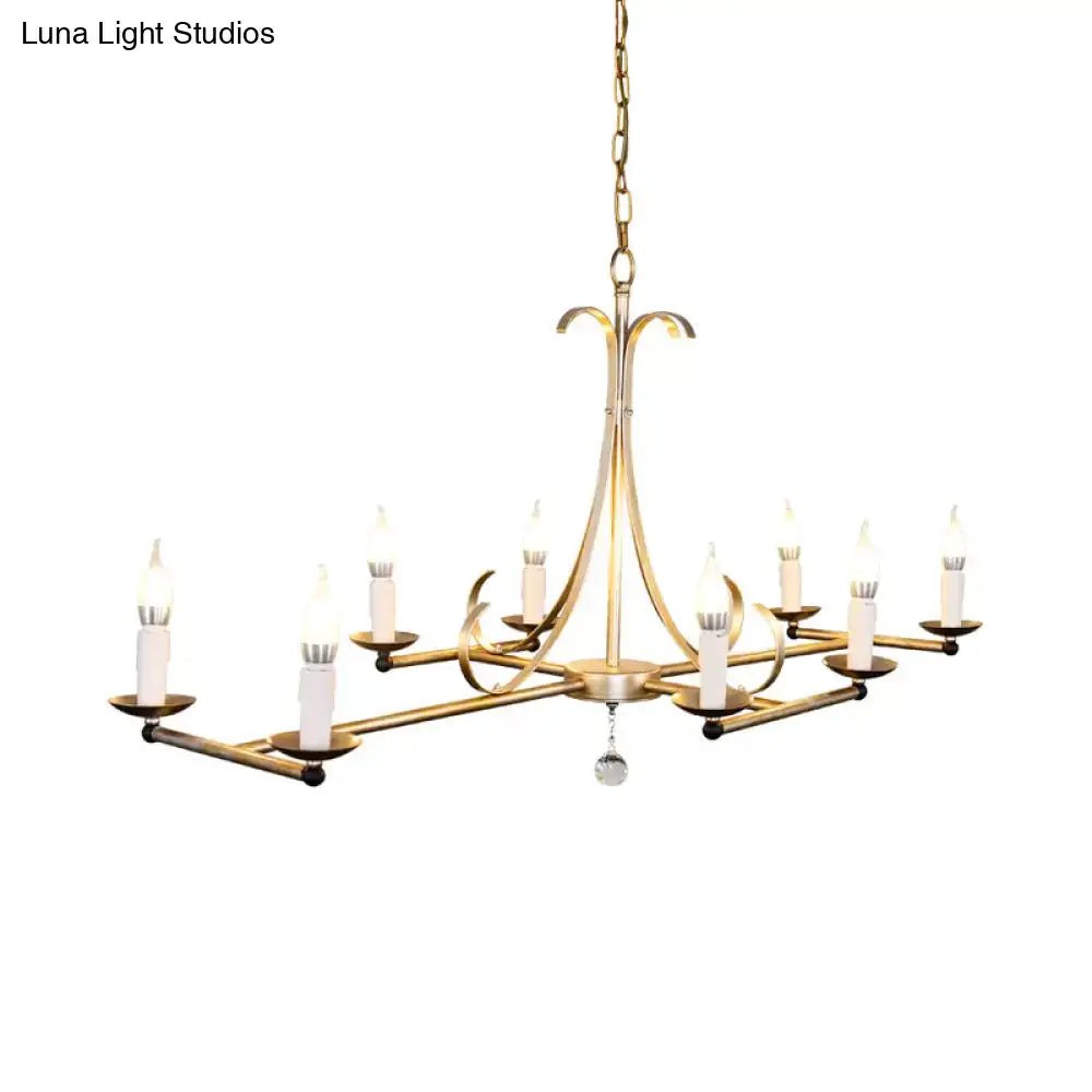 Gold-toned metal island chandelier with eight traditional candle bulbs and a dangling crystal accent