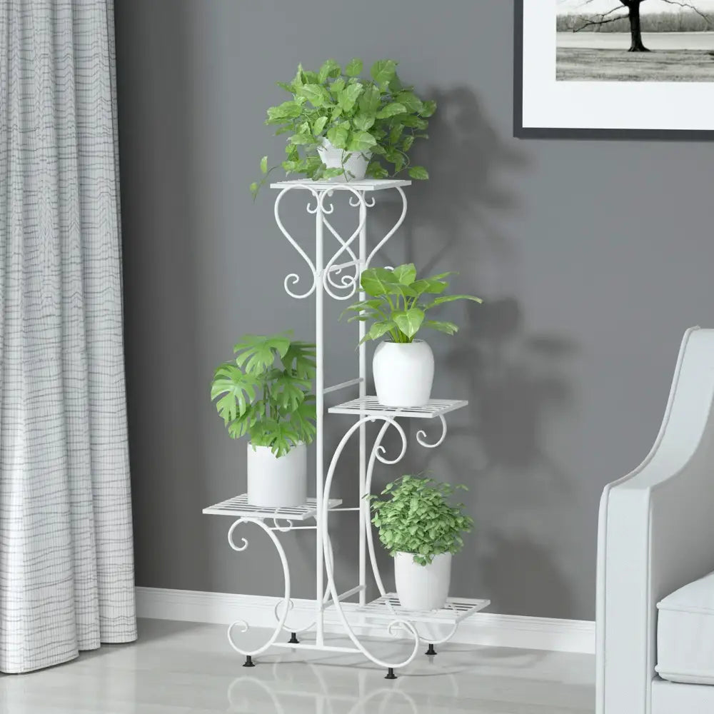 White wrought iron metal plant stand with ornate scrollwork and four tiers for holding four flower pots by DecorBites
