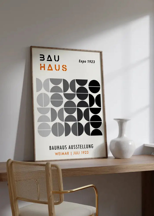 A minimalist framed decorbites mid century geometric canvas art with black gray white circles and bold orange bauhaus text