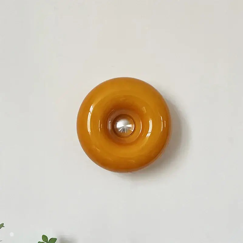 Glossy amber glass donut-shaped decorbites mid century modern desk lamp with central metallic reflector for modern desk use