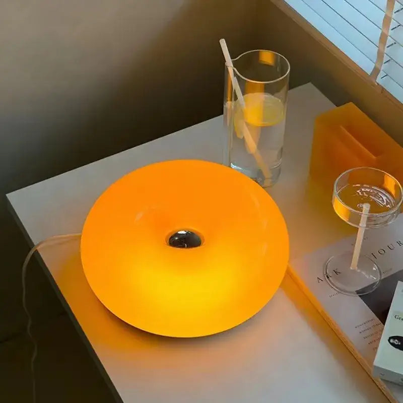 DecorBites™ mid century modern desk lamp with a glowing orange circular design and central dark hole for modern desk use