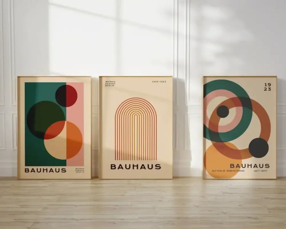 Three framed bauhaus posters with geometric mid century modern designs in muted earth tones for wall decor