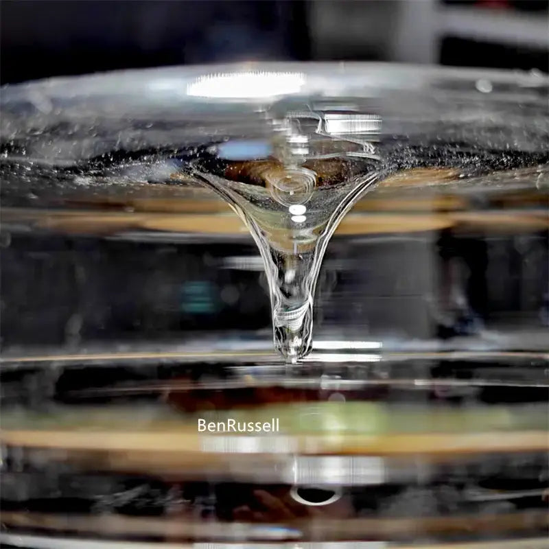 A clear transparent liquid droplet suspended above a glass bottle in the decorbites mini glass bottle terrarium kit for home decor