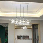 DecorBites minimal brass bubble pendant light with five clear glass heads and modern design suspended by thin cords