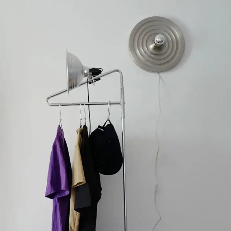 Silver metallic bauhaus lamp with adjustable arm and conical shade beside matching circular decorbites bauhaus fixture