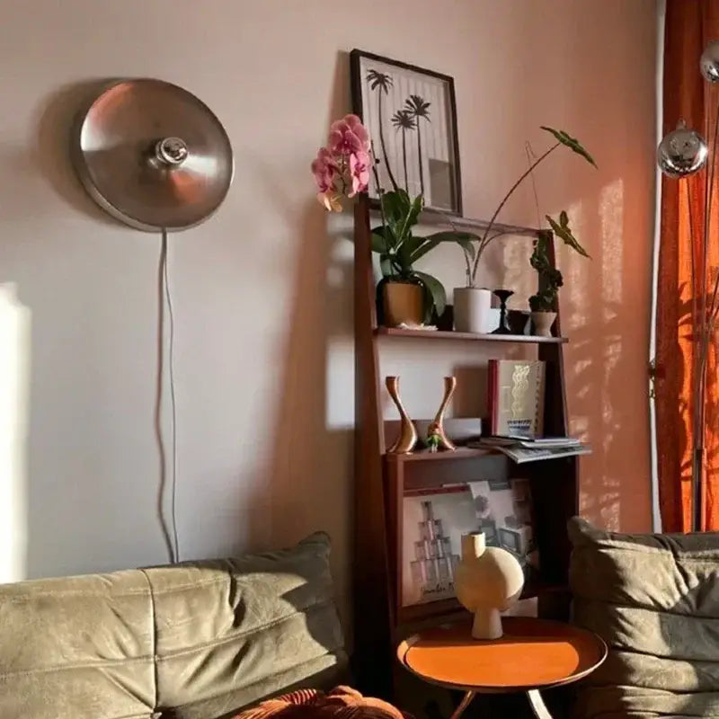 A sleek circular brushed metallic decorbites bauhaus lamp wall-mounted with a central bulb for minimalist lighting