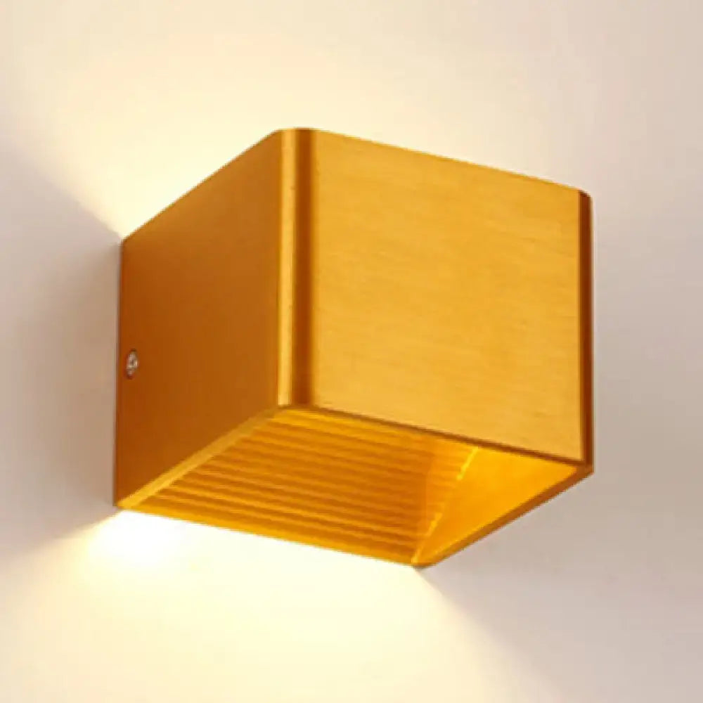 Gold-colored cube sconce light with brushed metal finish and slatted interior for decorbites minimalist cube shade decor