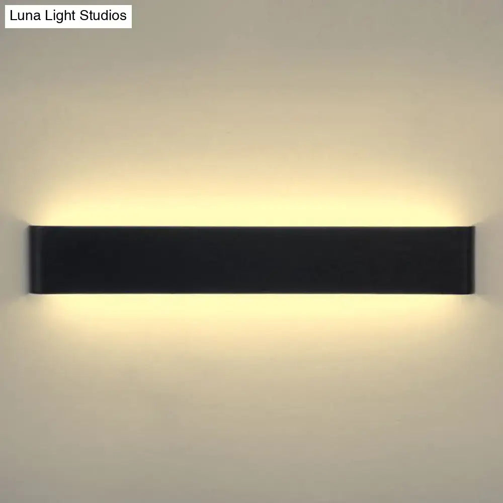 Black rectangular wall lamp with sleek modern design emitting warm white light for living room ambiance