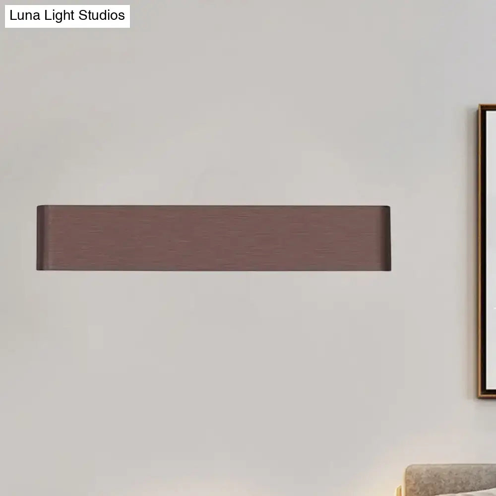 Modern rectangular wall lamp in matte bronze with brushed texture providing warm white light for living room use