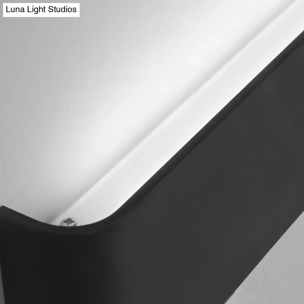 Minimalist black and silver wall lamp with sleek angular design providing warm white light for living room use