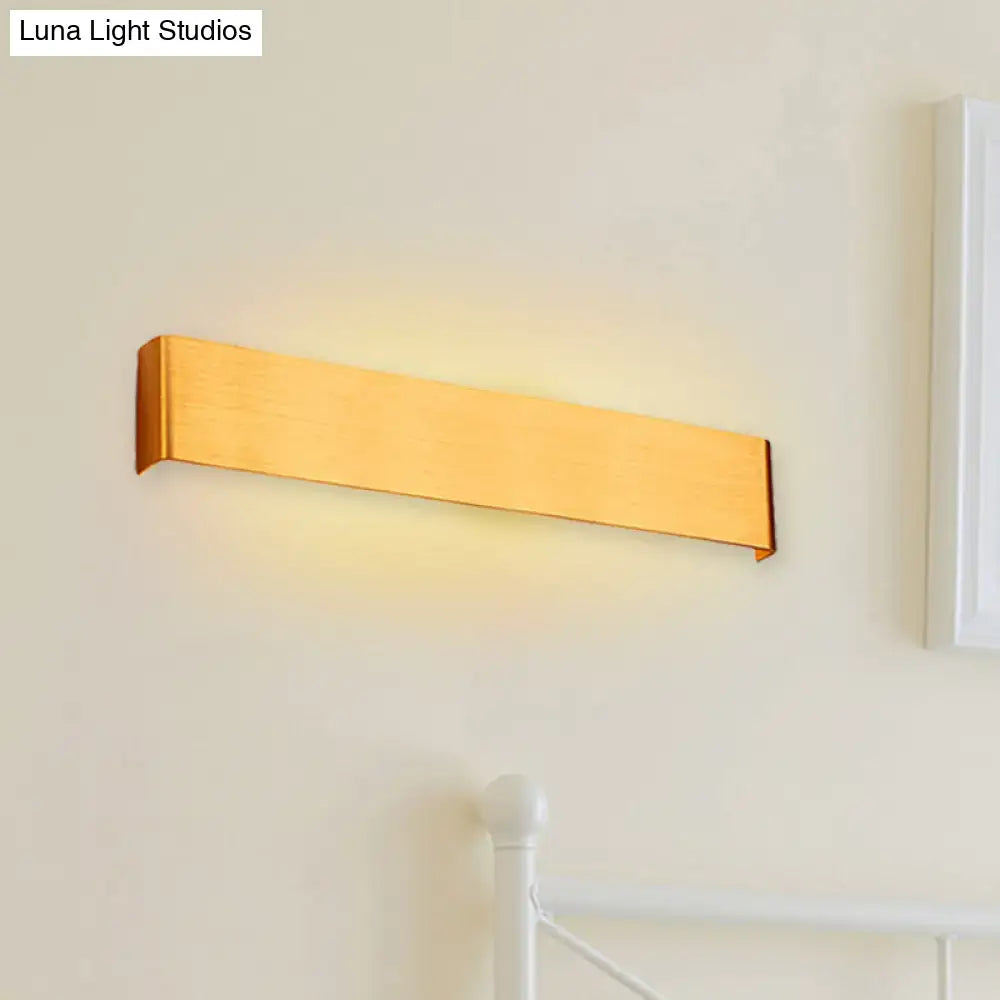 A sleek rectangular gold finished wall lamp with modern design providing warm white light for living room use