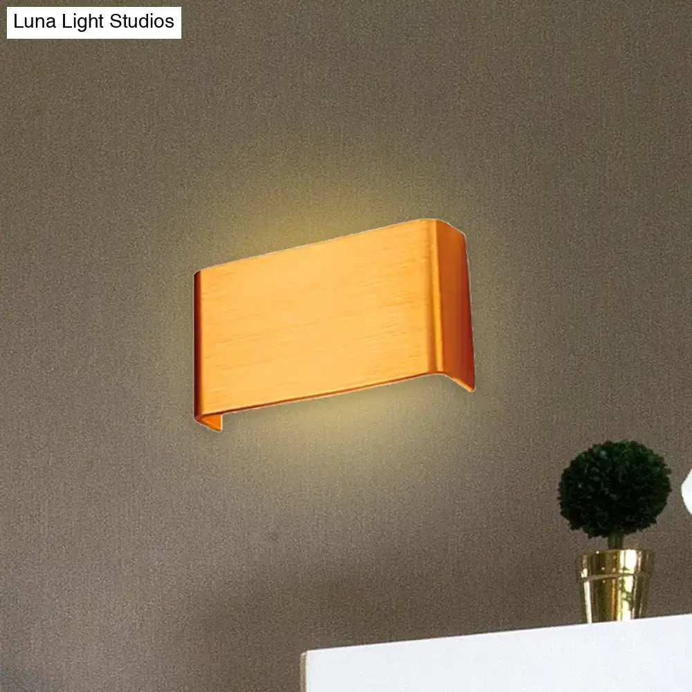 Modern copper-finished wall lamp with sleek angular design providing warm white light for living room use
