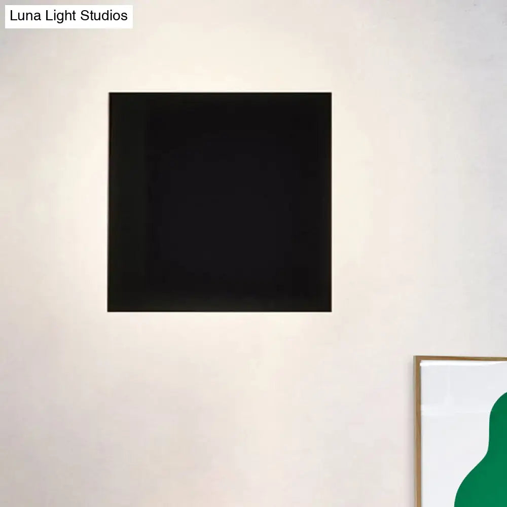 A sleek minimalist black square wall washer light wall-mounted as sconce lighting for living room use