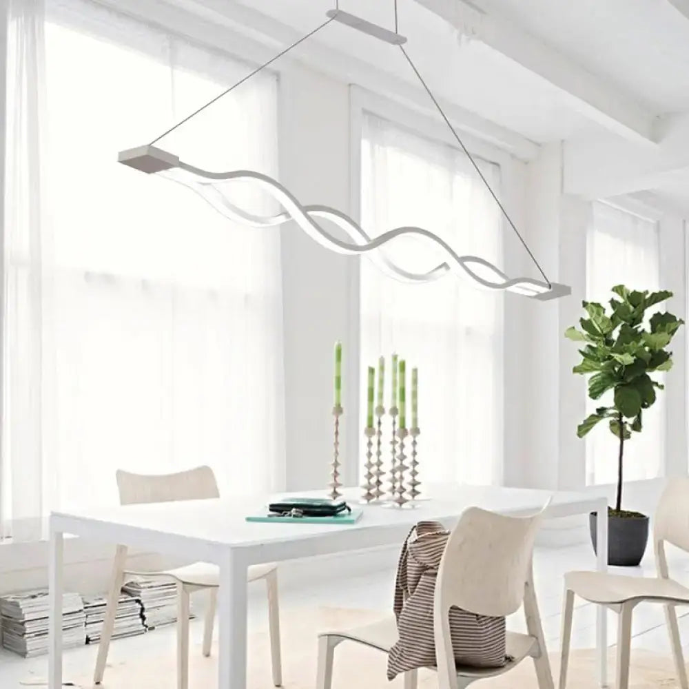 Modern white DecorBites™ led acrylic pendant with wavy suspended lighting fixture hanging above dining table
