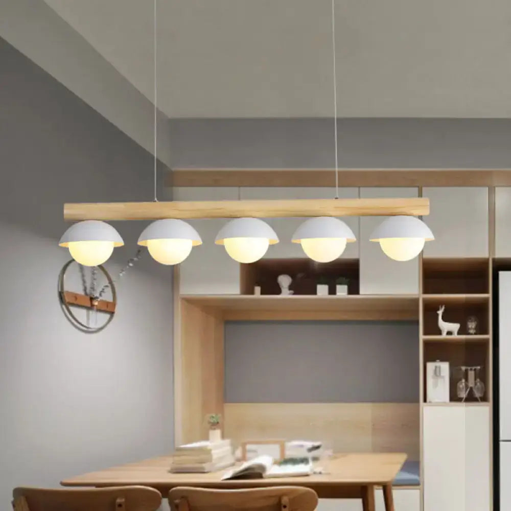 Modern minimalist wood island pendant with natural wood bar and five white grey dome-shaped shades for kitchen island lighting