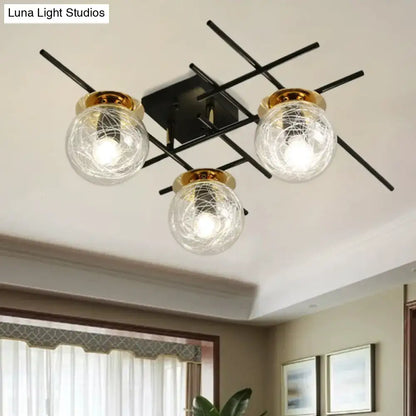 Modern black metal semi-flush ceiling light with three clear smoke gray glass globes and gold-toned rims for bedroom use