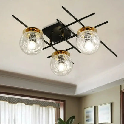 Modern black metal ceiling fixture with three clear smoke gray glass globes and gold metallic rims for bedroom lighting