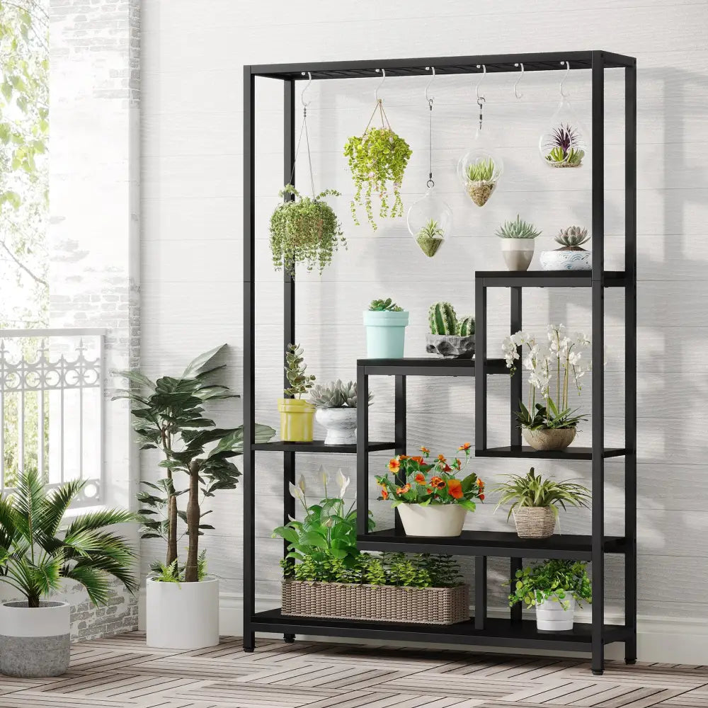 DecorBites™ modern black metal plant stand with five shelves and hanging hooks holding various potted plants