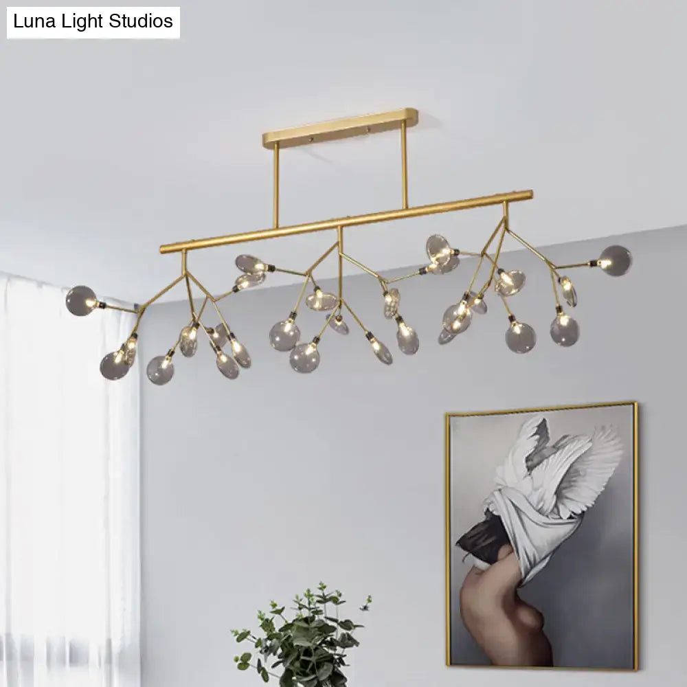 Gold-toned modern firefly island pendant with branching arms and clear glass globe bulbs for dining room lighting