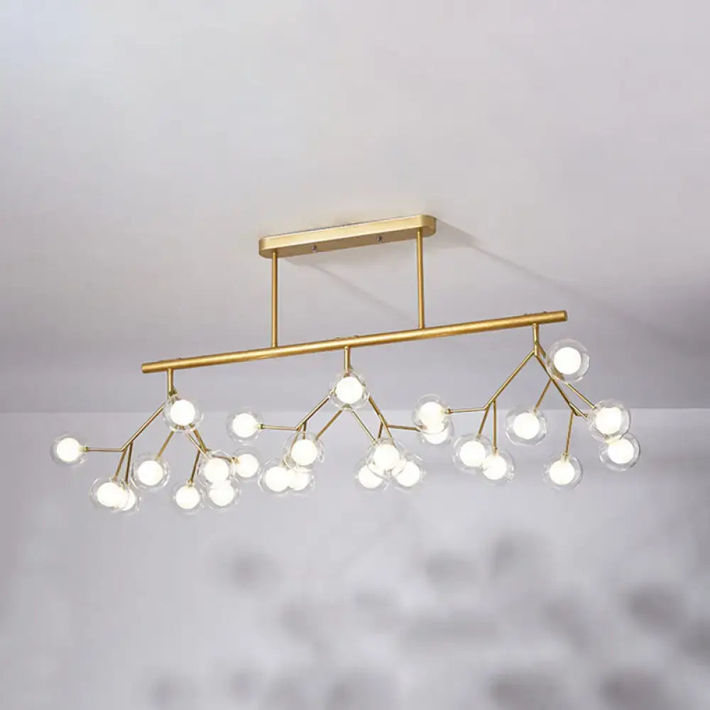 Gold-toned modern acrylic firefly island pendant with branching design and clear glass globes for dining room lighting