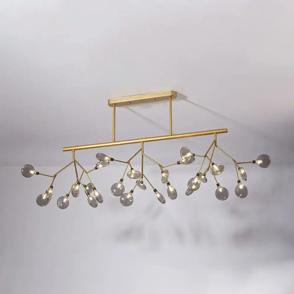 Gold-toned modern firefly island pendant with branching arms and clear glass globe bulbs for dining room lighting