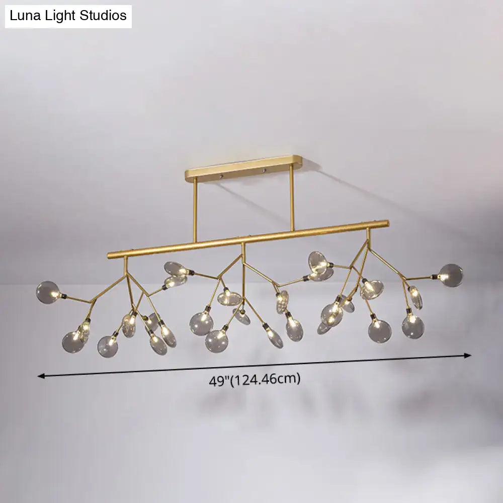 Gold-toned modern firefly island pendant with branching arms and clear glass globe bulbs for dining room lighting