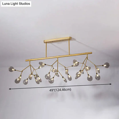 Gold-toned modern firefly island pendant with branching arms and clear glass globe bulbs for dining room lighting