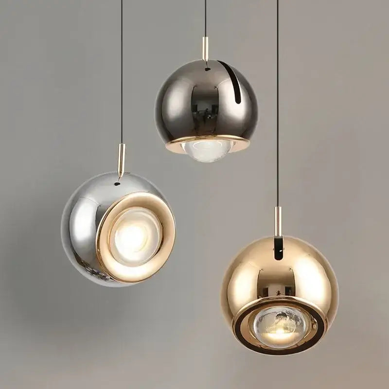 Three spherical metallic silver gold and bronze decorbites adjustable led pendant lights with central illuminated bulbs
