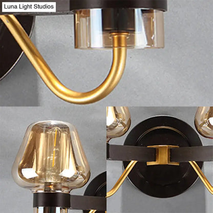 Modern black and gold mushroom sconce light fixture with amber glass shades and curved brass arms for living room