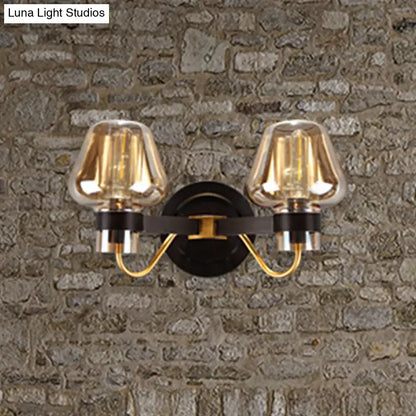 Modern black and gold mushroom sconce light fixture with amber glass shades and black metal arms for living room use