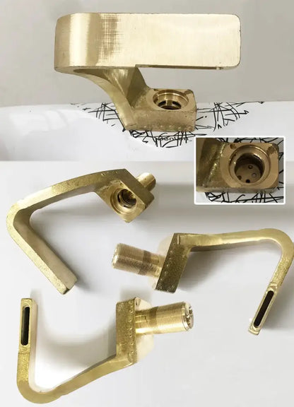 Gold-colored brass window latch components with polished finish and threaded bolts for modern black bathroom use