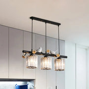 DecorBites™ modern black cylinder island light pendant features three crystal glass shades with white bird accents
