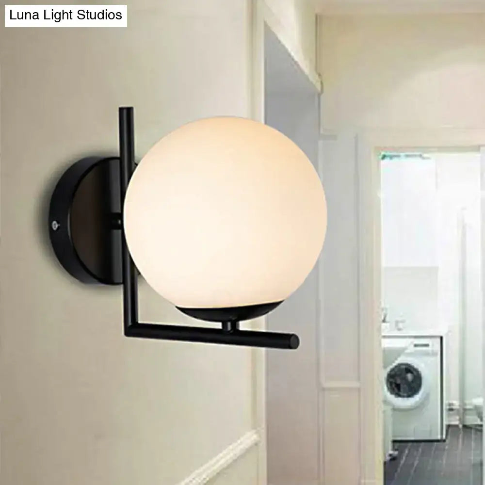 Modern black metal wall sconce with a black opal glass globe for bedroom lighting fixture with frosted finish