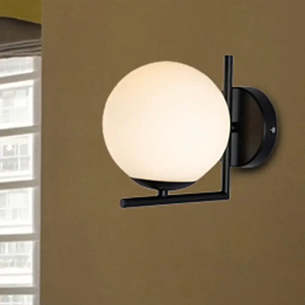 Modern black metal wall sconce with a frosted black opal glass globe for bedroom lighting fixtures