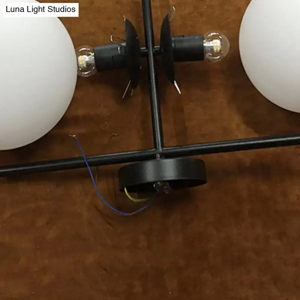 Modern black and white spherical wall light fixture with black metal chandelier and frosted glass globe shades