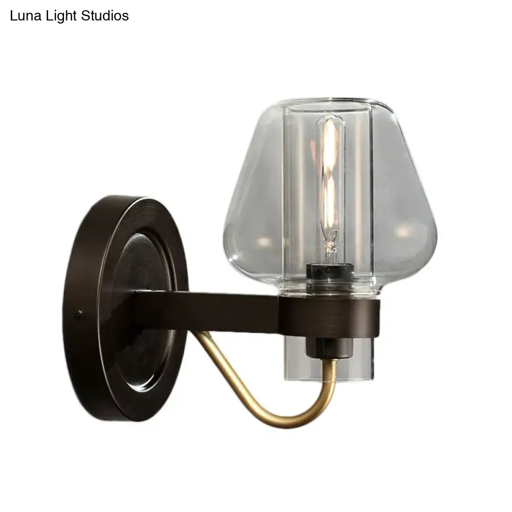 Modern black and brass wall sconce with a glass mushroom shade and dark bronze base for bedroom lighting