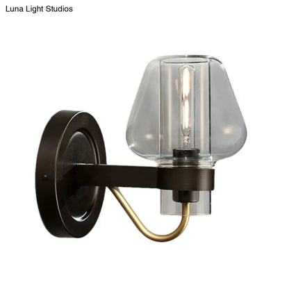 Modern black and brass wall sconce with a glass mushroom shade and dark bronze base for bedroom lighting