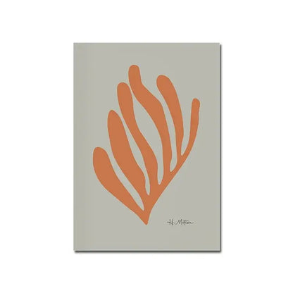 A minimalist notebook with a soft gray cover and orange abstract seaweed design complementing a modern black and white canvas print for home decor
