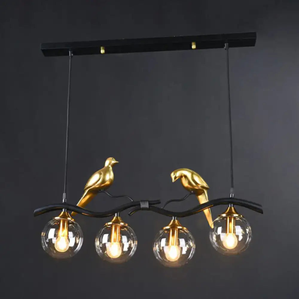 Gold-colored bird-shaped island pendant light with clear glass globe bulbs and black metal branch design for dining room