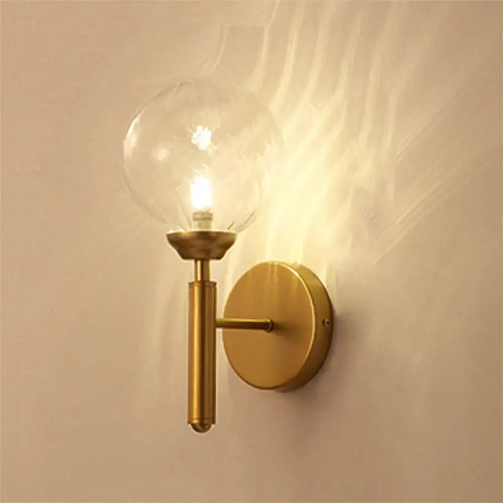 Modern brass glass sphere wall lamp fixture with clear glass globe bulb suitable for bedroom lighting