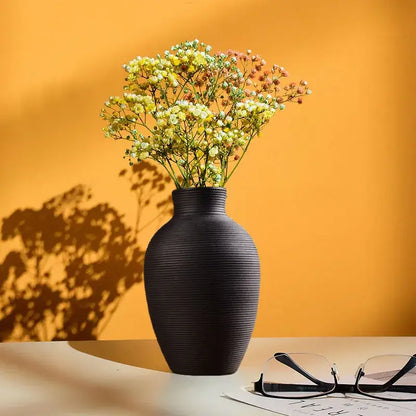 Decorbites modern black ribbed ceramic nordic vase holding yellow and white babys breath for home decor