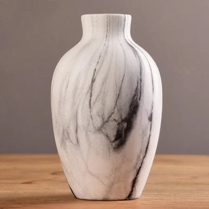 A sleek white ceramic nordic vase with black marble-like veining for modern home decor by DecorBites™