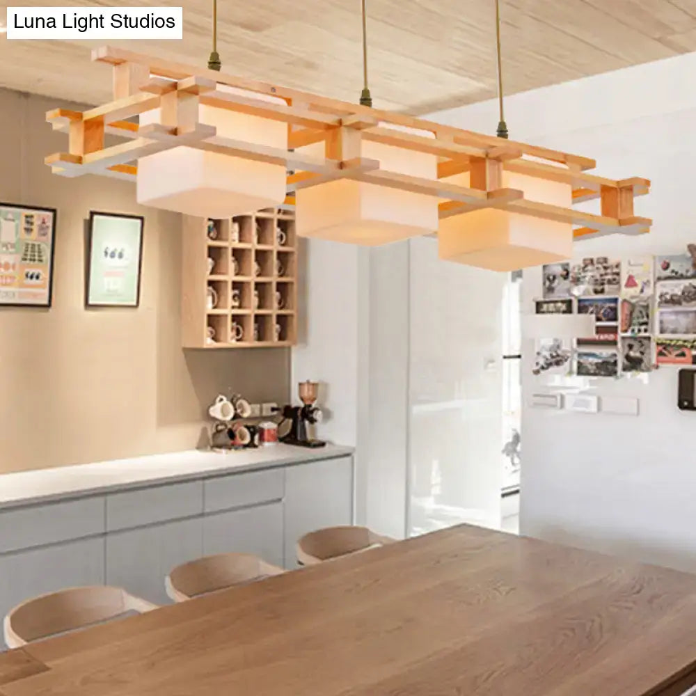 Modern cream glass cube pendant light with three wooden heads featuring geometric layered warm-toned shades