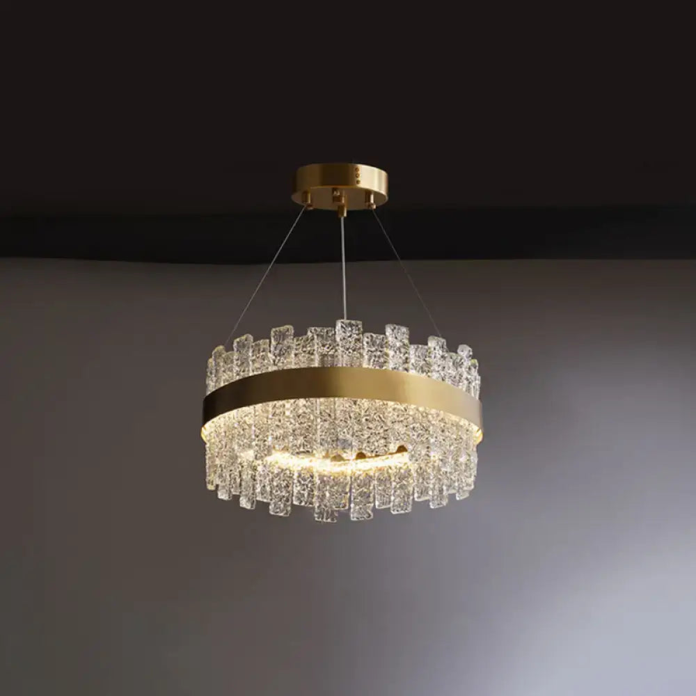 Gold-toned brass plated DecorBites™ pendant light with crystal loop design and cascading textured glass pieces