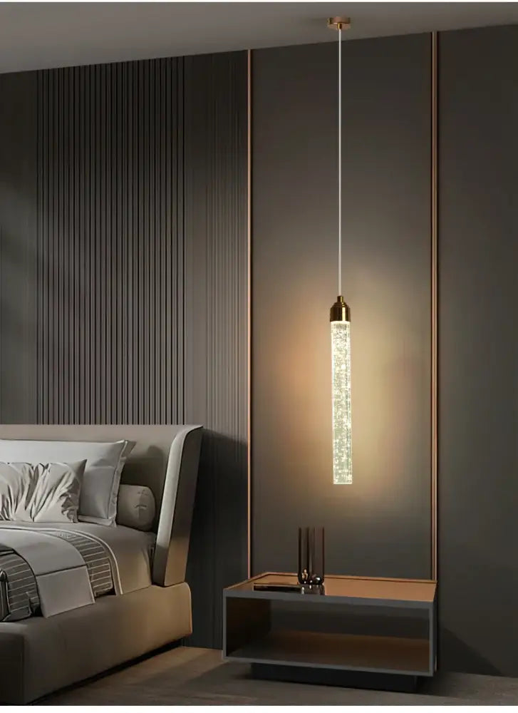DecorBites™ modern crystal pendant light with cylindrical crystal body and gold fixtures suspended by thin cord