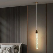 Decorbites modern crystal pendant light with gold fixtures featuring a cylindrical glass body filled with crystals