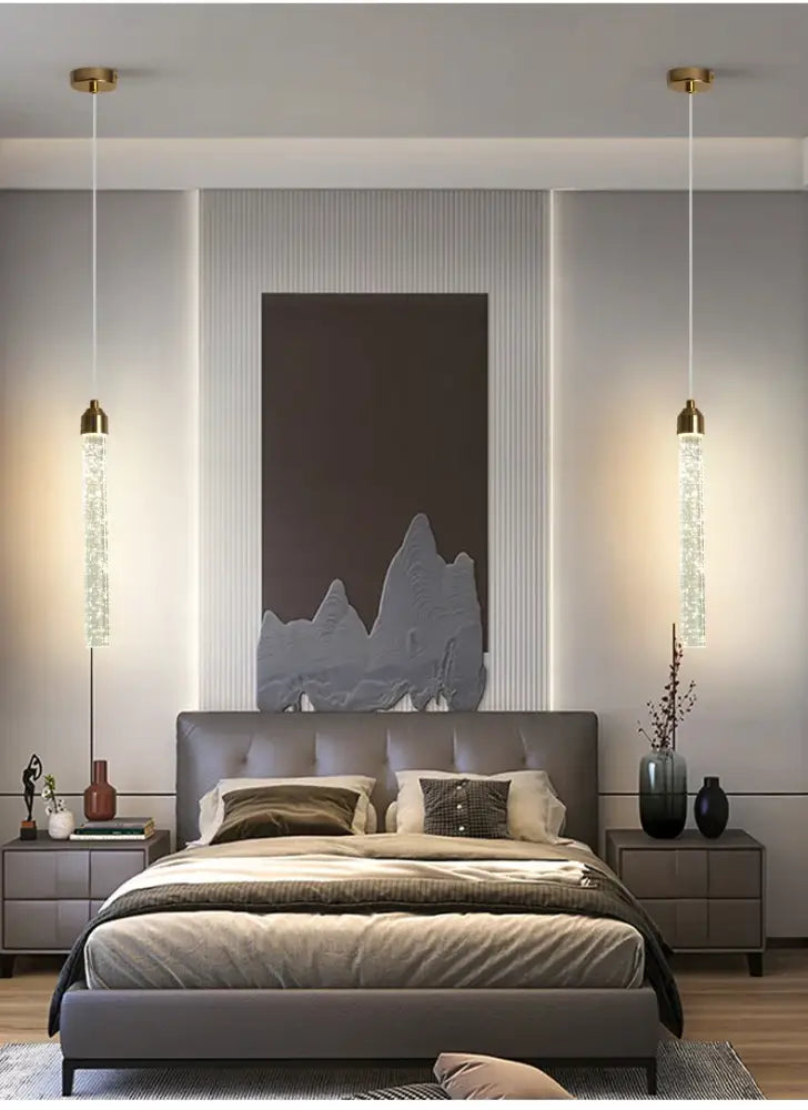 Decorbites modern crystal pendant light with gold fixtures features cascading crystal beads above the bed