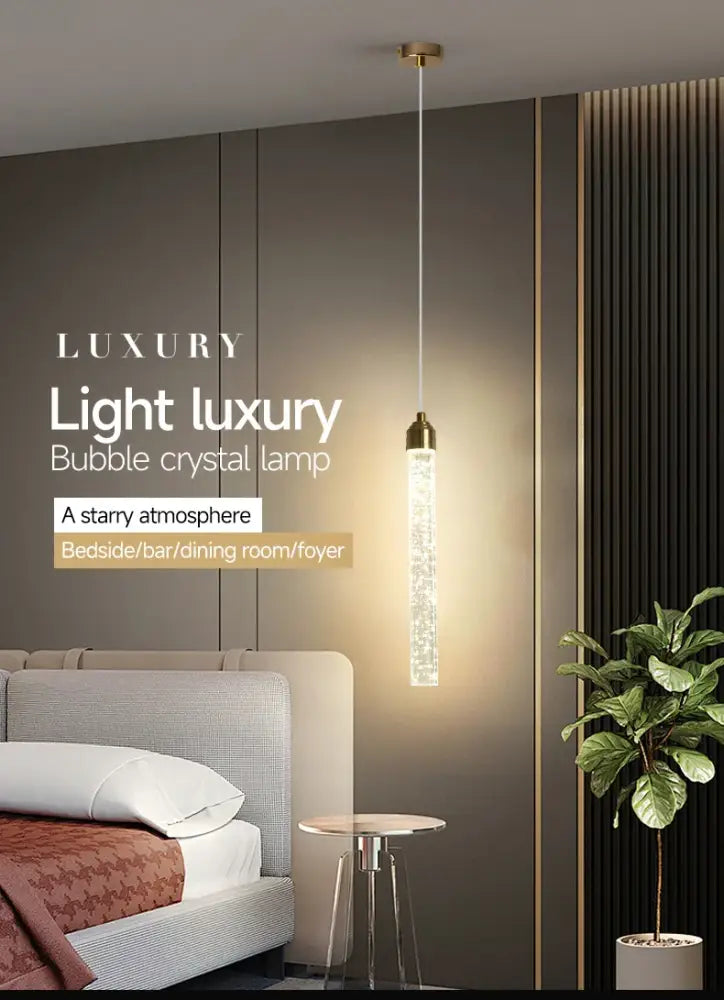 A sleek vertical decorbites modern crystal pendant light with gold fixtures and bubble crystal design