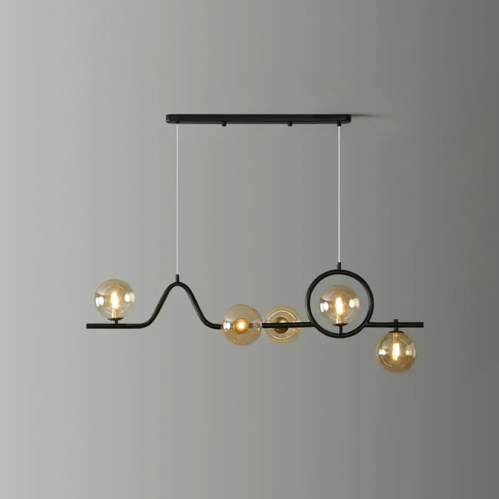 Black metal decorbites™ modern curve island ceiling light with five amber glass globe bulbs for dining room